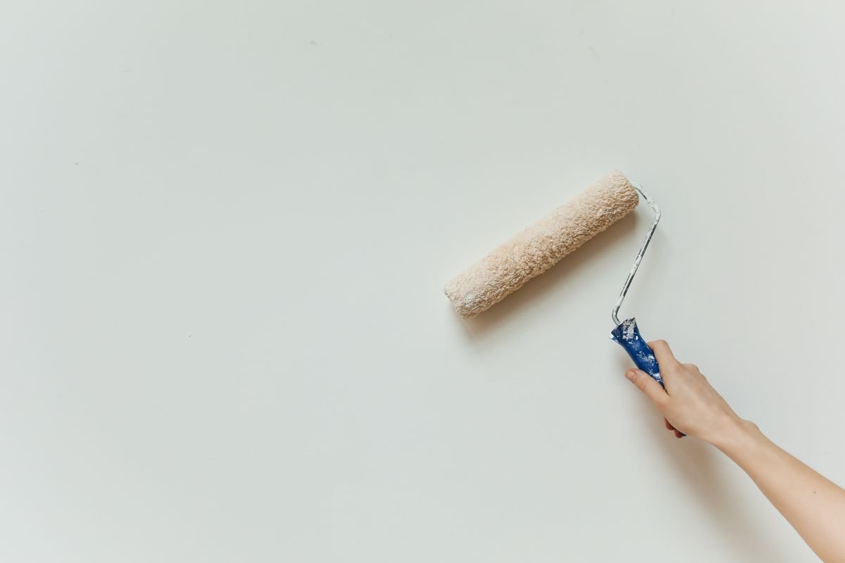 Close-up of a paint roller being used on a wall during renovation