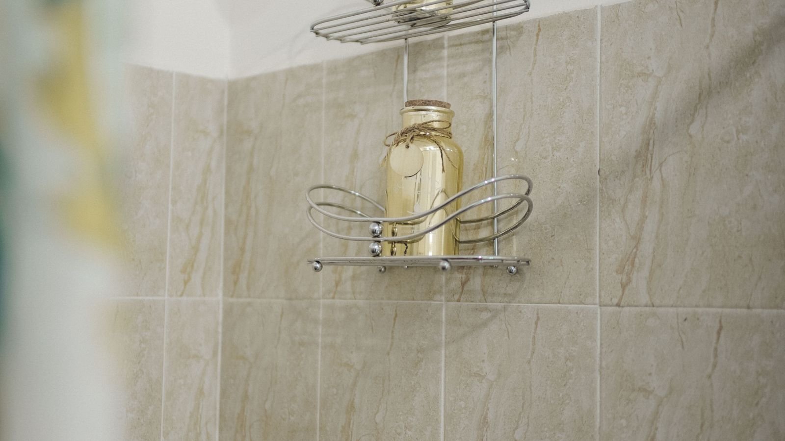 Compact tiled bathroom with a glass shower enclosure and wall-hung basin