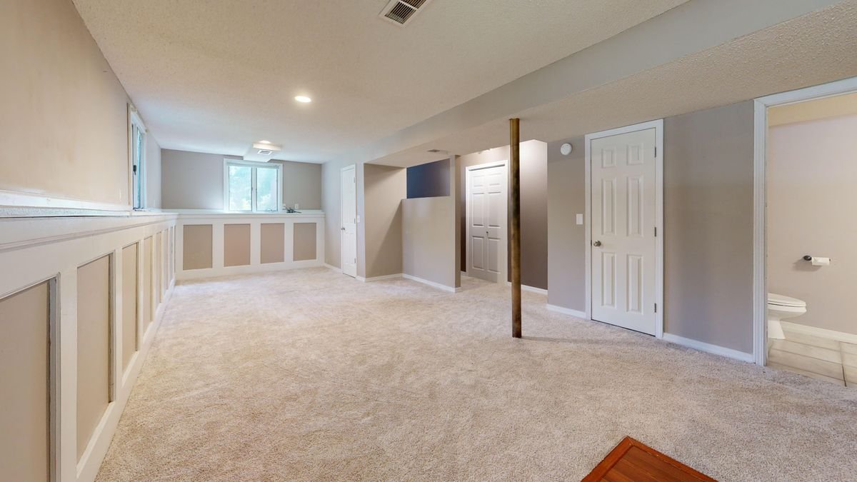 Finished basement with carpet flooring and recessed lighting