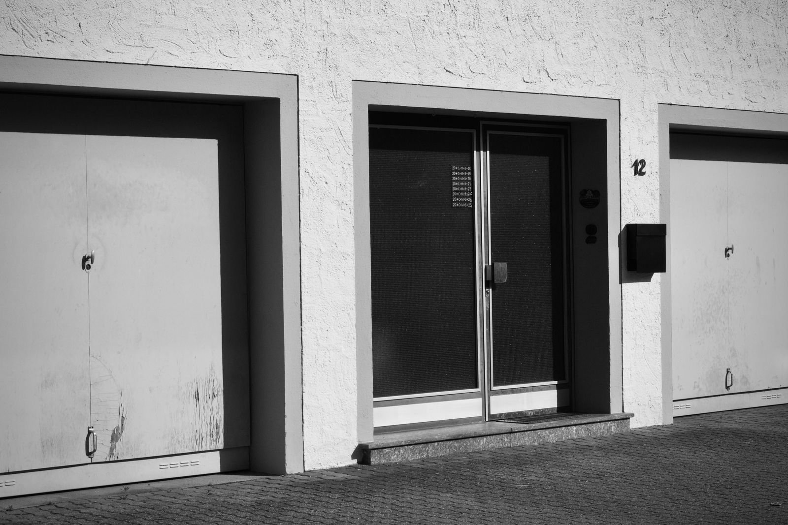 A pale sectional garage door on a suburban home