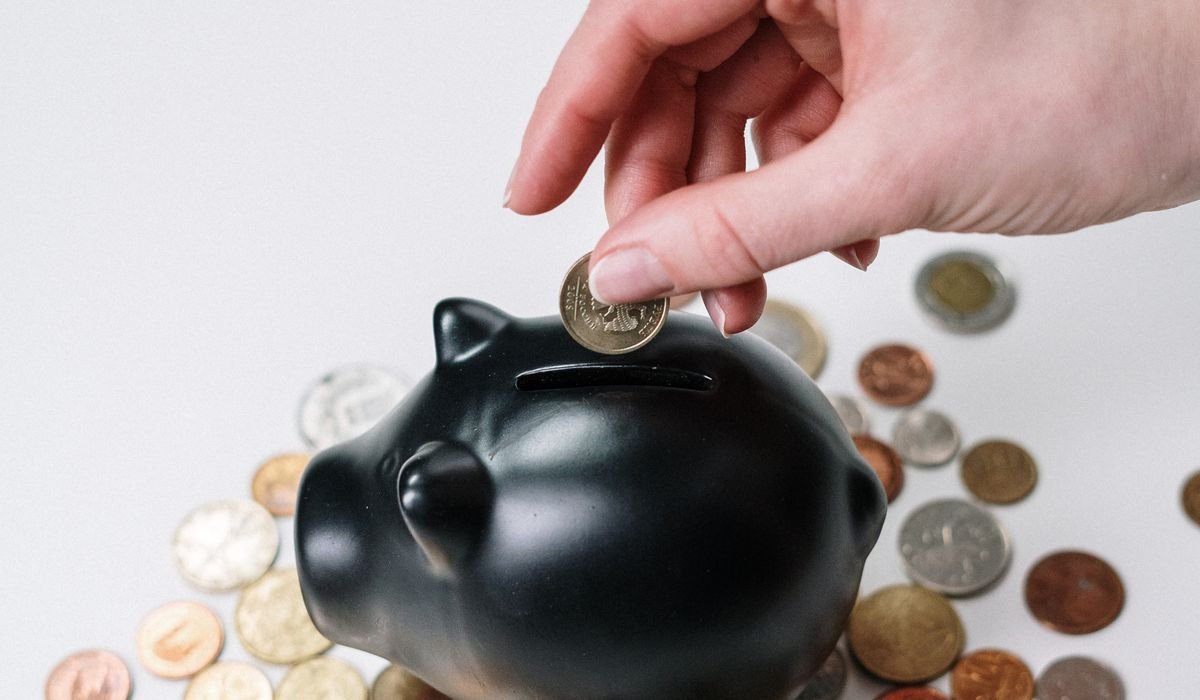 Coins being dropped into a savings jar