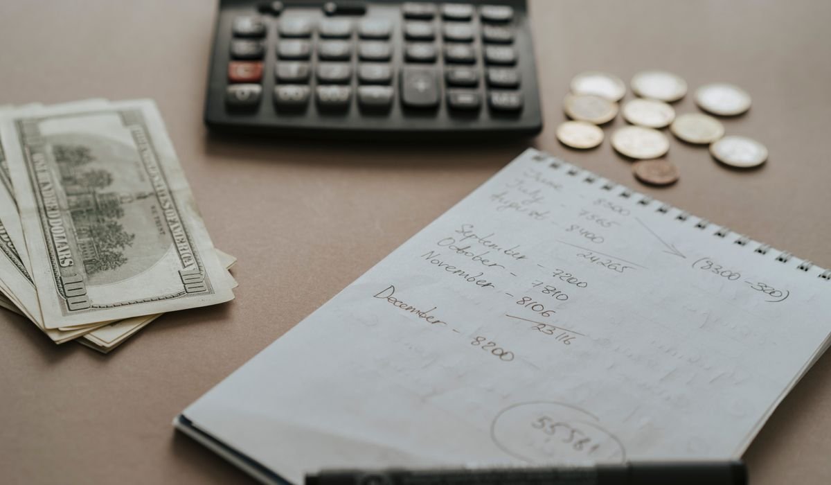 Calculator and notebook on a desk for budgeting