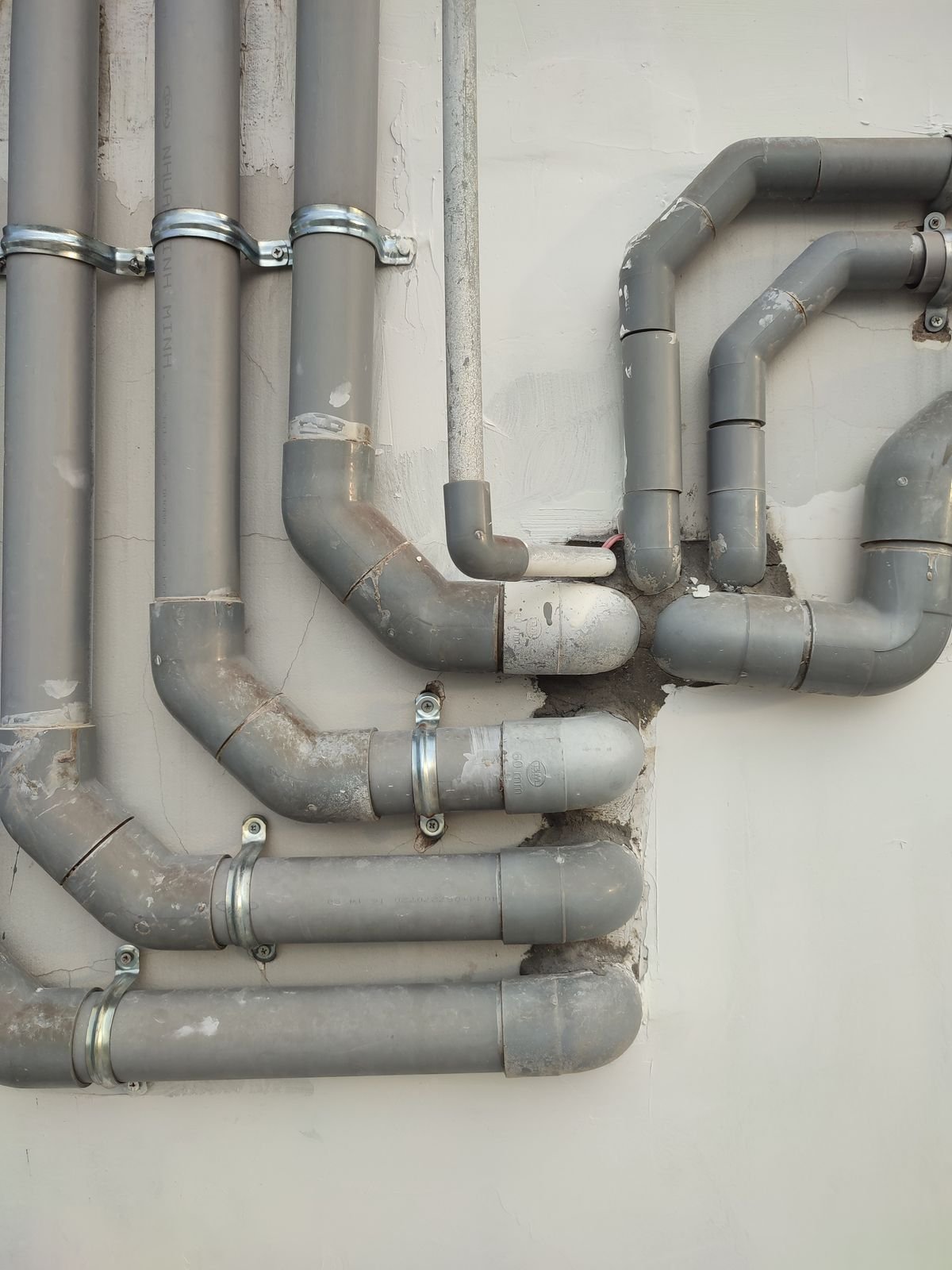 Interconnected metal pipes running along a wall