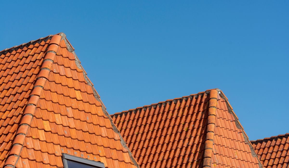 Pitched residential roof against a clear sky