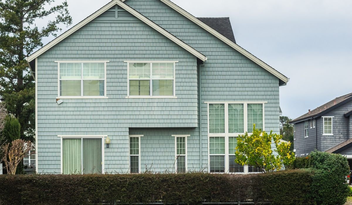 House clad in pale blue lap siding with white trim