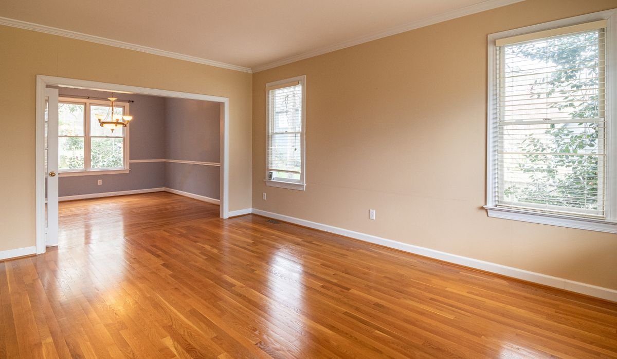 Empty room with plank flooring running toward a window