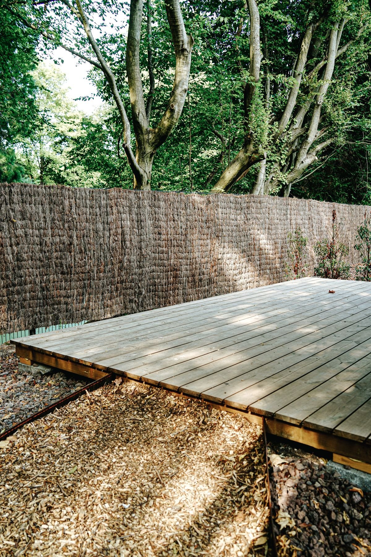 Wooden deck surrounded by trees and a privacy fence